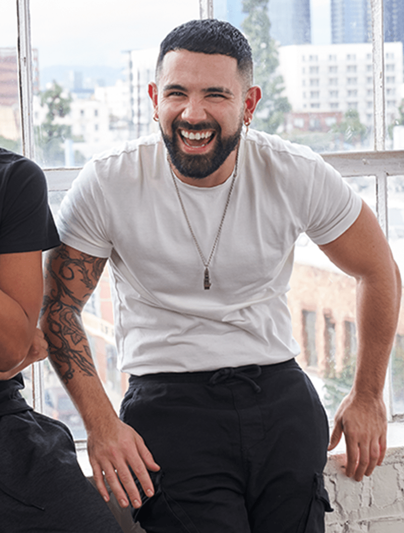 Male barber in a white shirt laughing with model